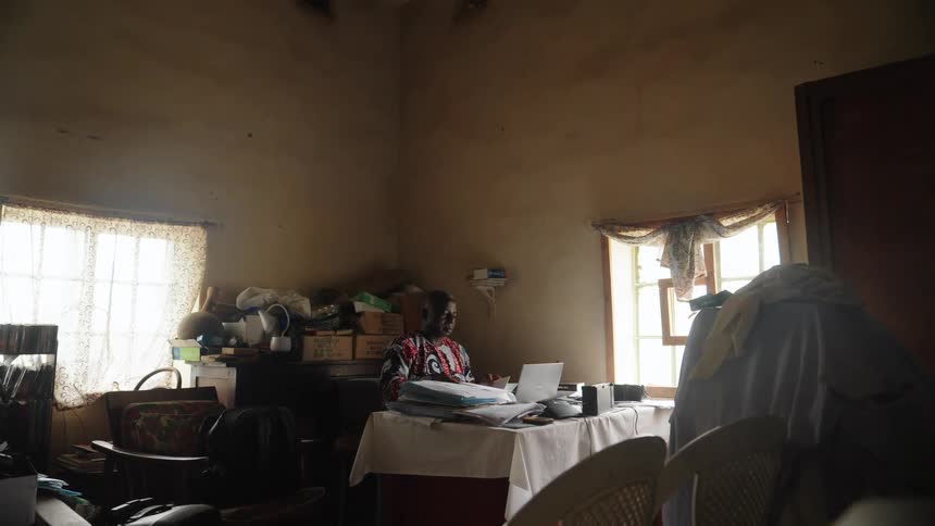 Man sits at a table in his home office doing paperwork during the daytime