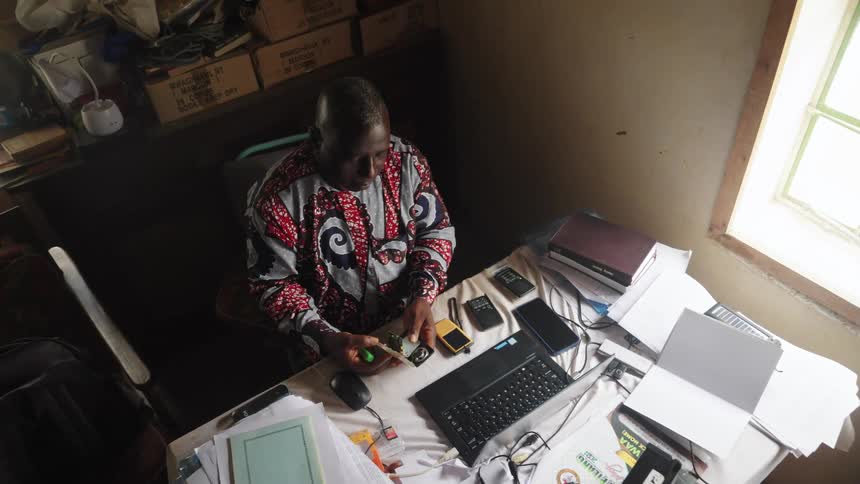 Man sitting at table with multiple mobile devices