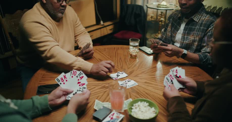 Four people sitting at a table playing cards