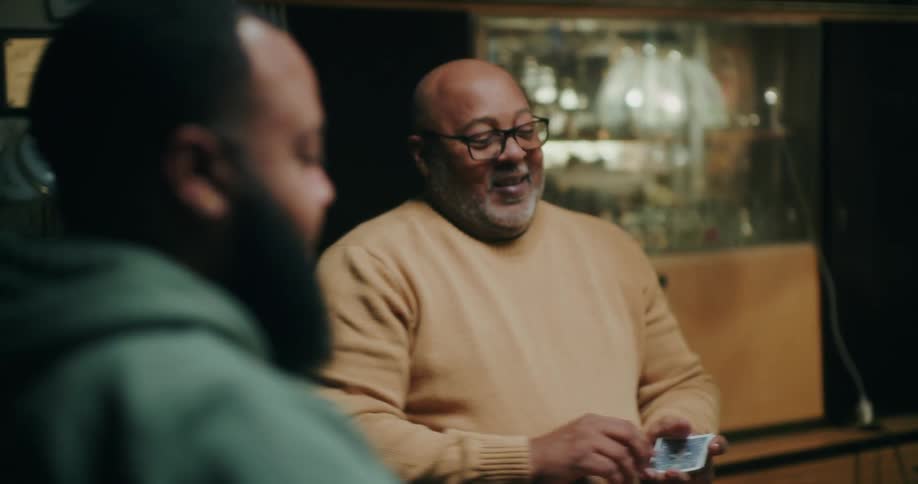 Two men sitting at a table playing cards