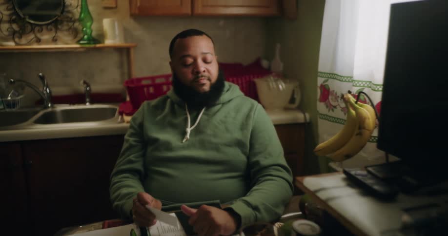 Bearded man sitting at a table in the kitchen
