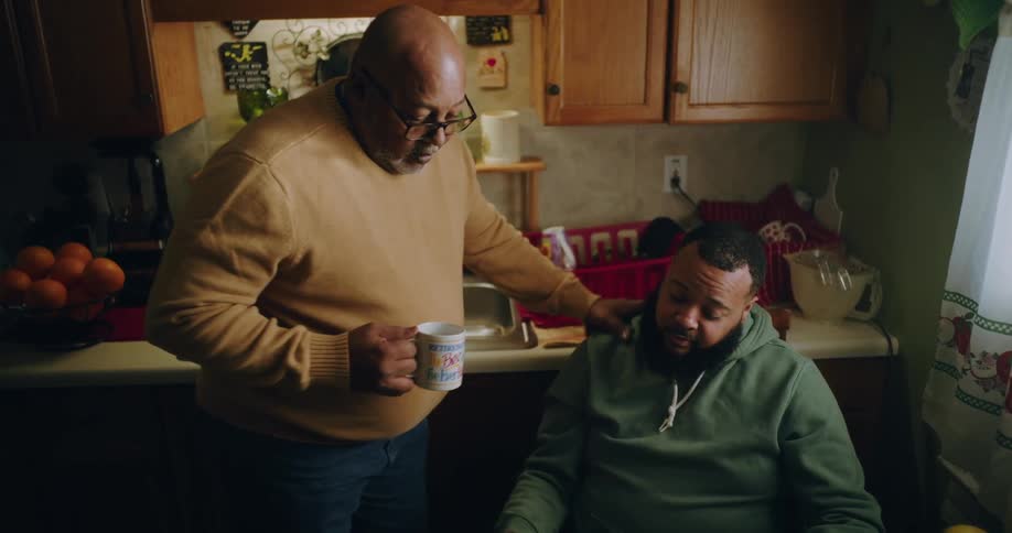 A father and son are talking in the kitchen