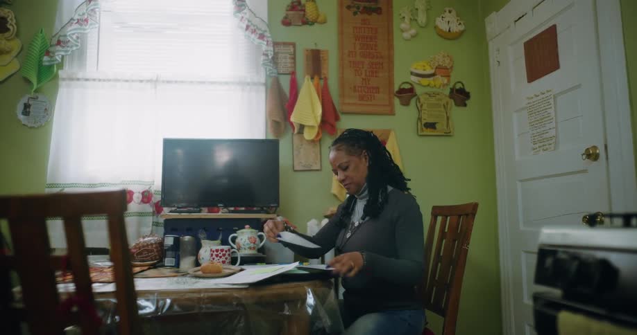 A clip of a woman indoor making calculations