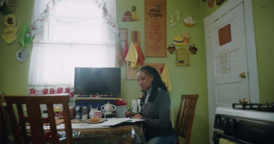 Woman sitting at a table writing in a notebook