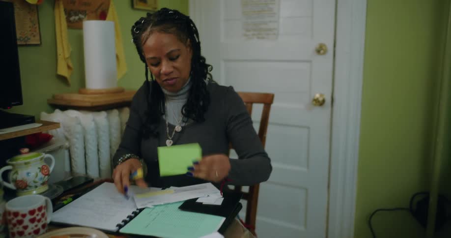 Woman sitting at a small table interacting with some documents