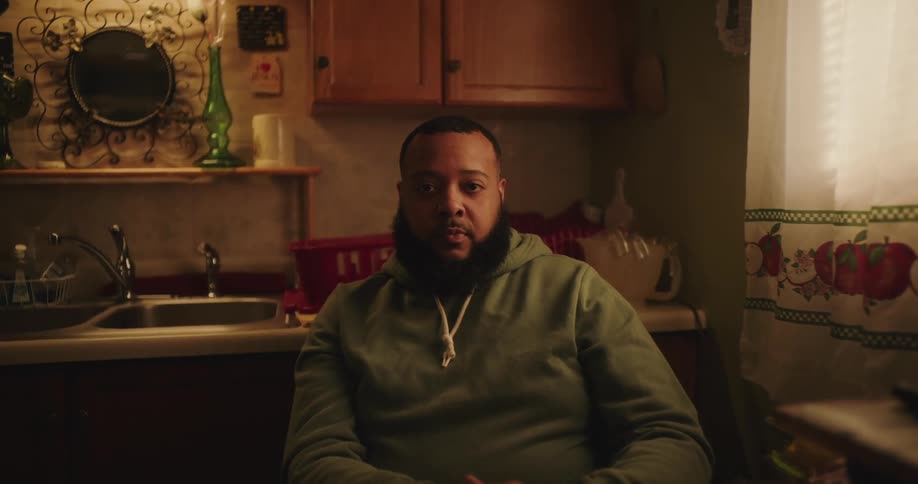 Man sitting at a table in the kitchen being thoughtful