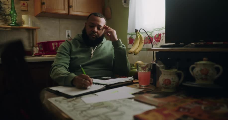 Man sitting writing in a notebook