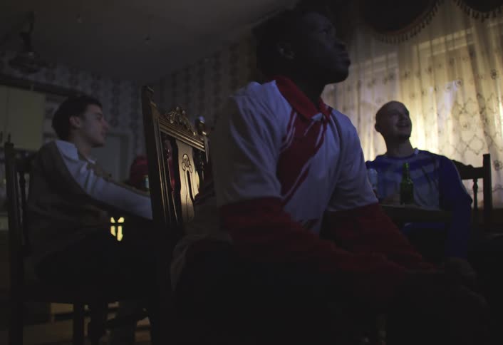 Boy sitting at table with his friends watching together