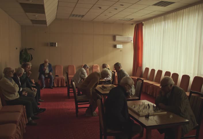 Men sit down to play chess in the hall