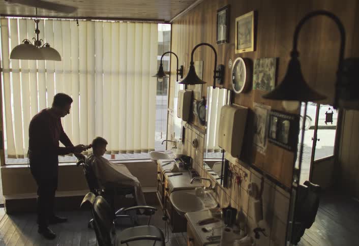 A boy is getting a haircut in the barbershop