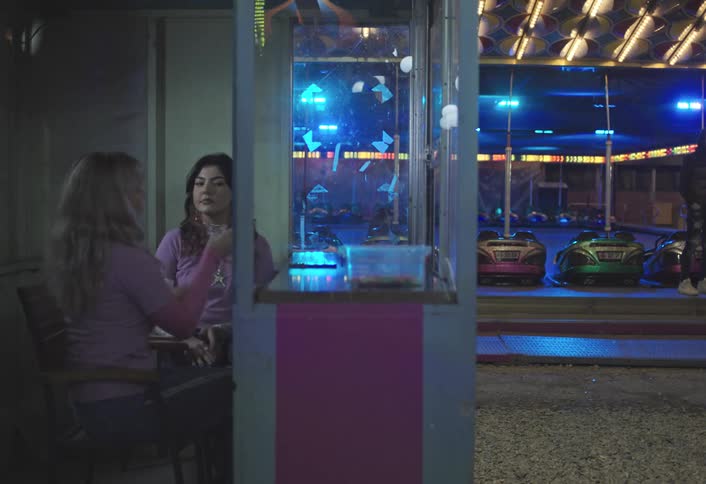 Two employees at the carnival are taking a selfie in the booth
