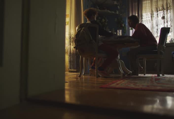 A footage of people discussing while sitting on the dinning table