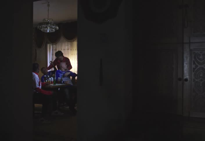 Group of people sitting around a table in a dimly lit room