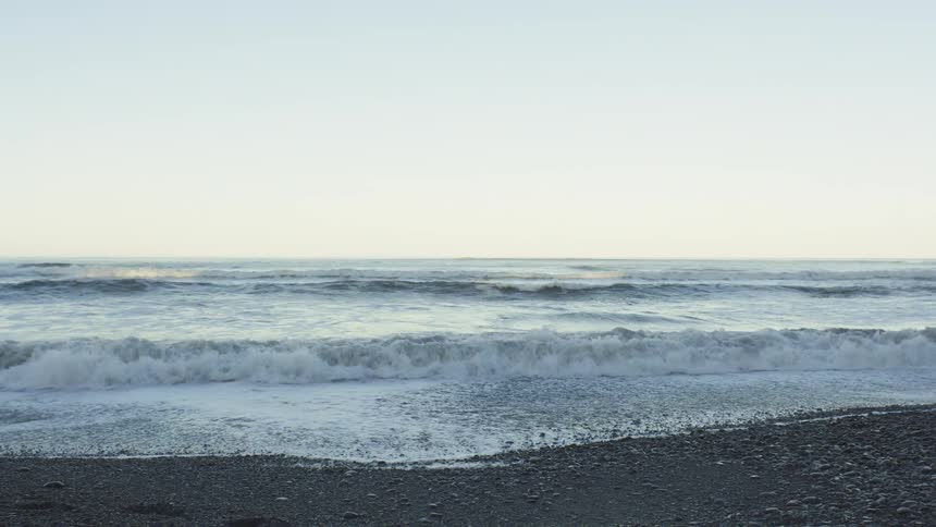 Some sea waves breaking on a beach and making several foams