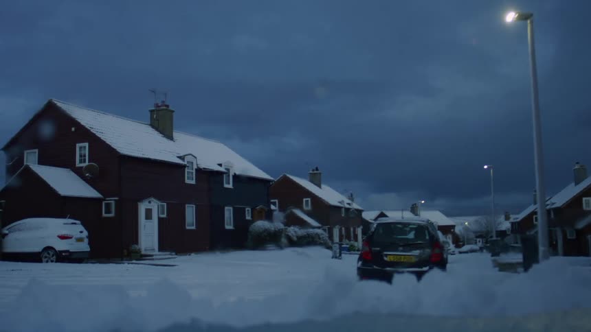 Urban area with houses covered in snow at night
