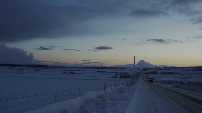 Road with vehicle traffic through a region covered by snow