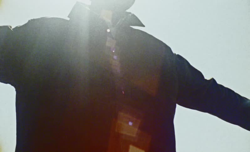 A man raises his arms and turns around
