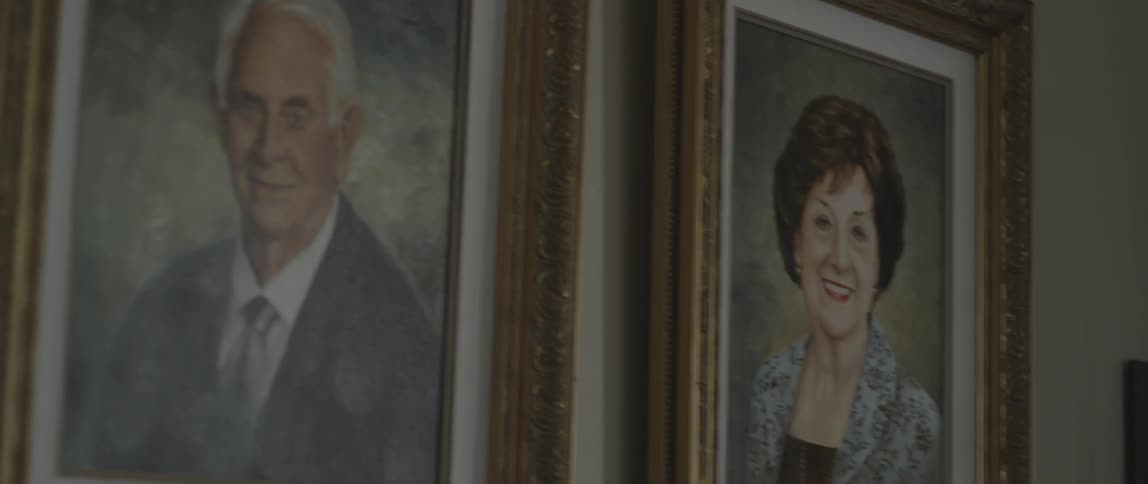 Portraits of an elderly gentleman and lady  hanging on a wall