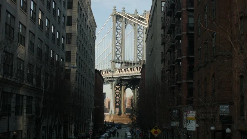 A city street leads to a bridge ahead