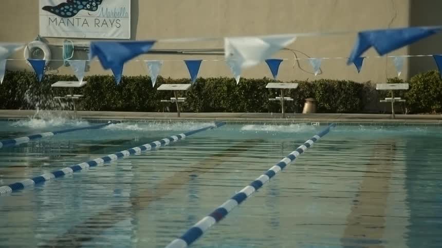 Children dive into a pool to race