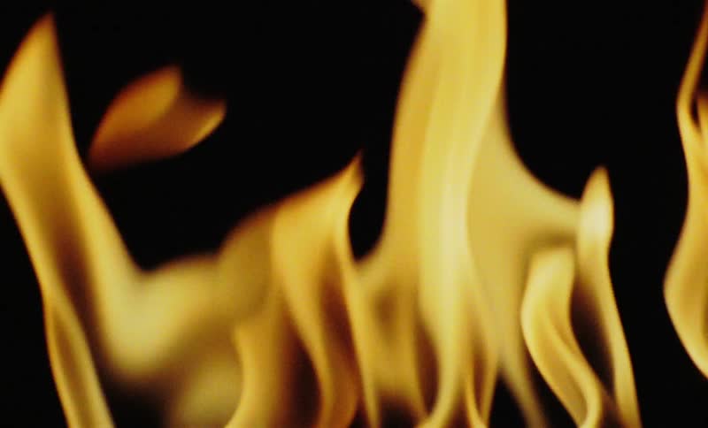 Several orange fire flames moving randomly on a black background