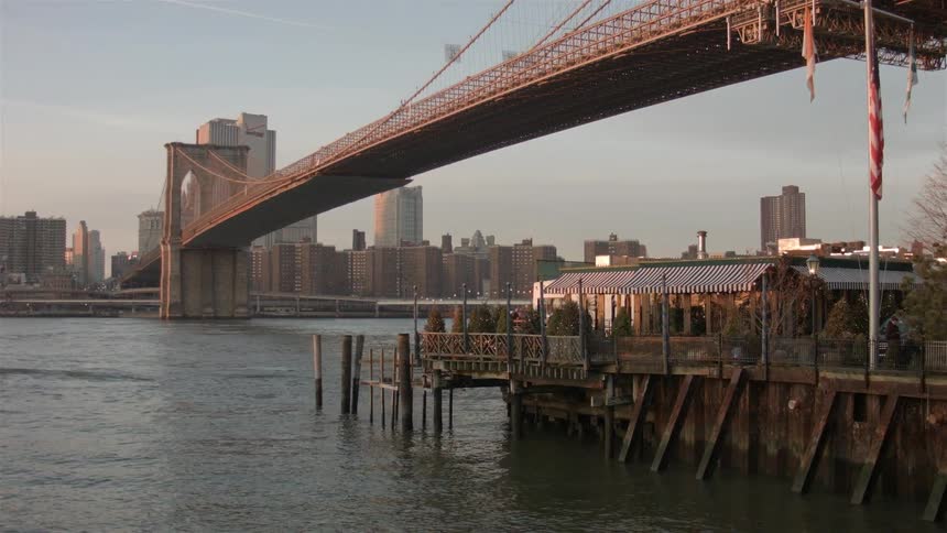 View of a bridge over a river next to a city
