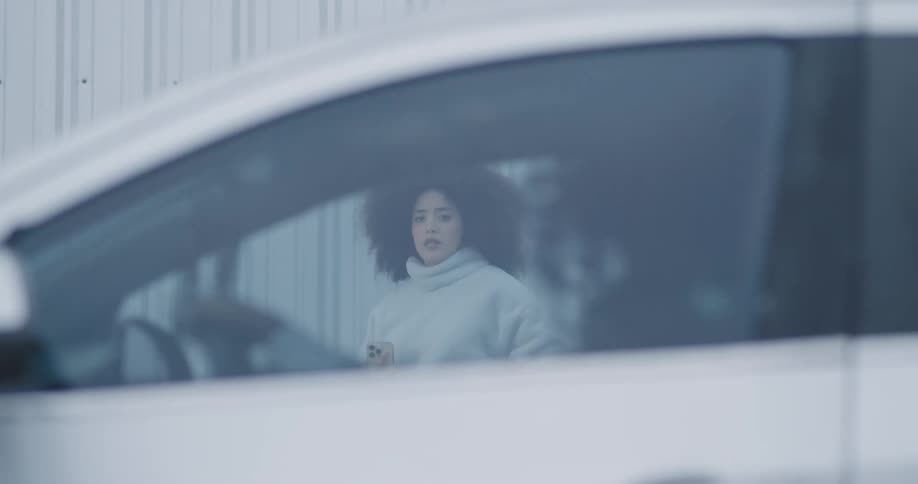A clip of a person going crazy inside a car while a lady watch surprisingly
