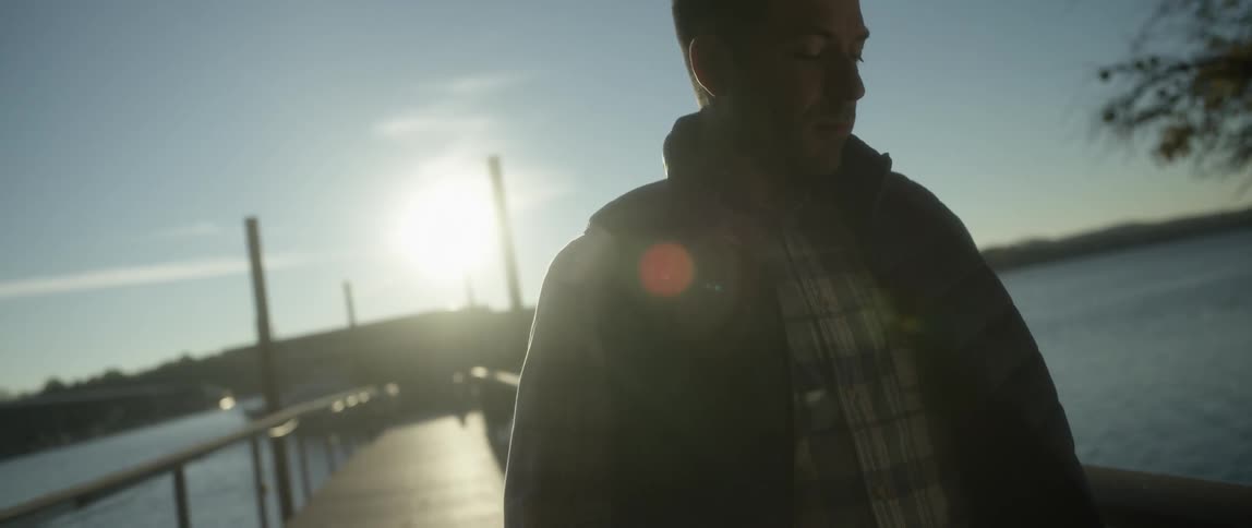 Man standing on the pier looks down at his feet