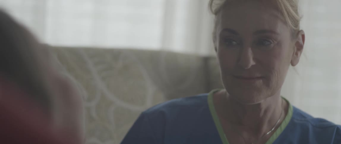 A nurse smiles and talks to a patient