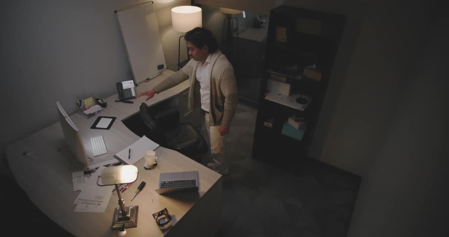 Man walking into an office room and sitting on the chair