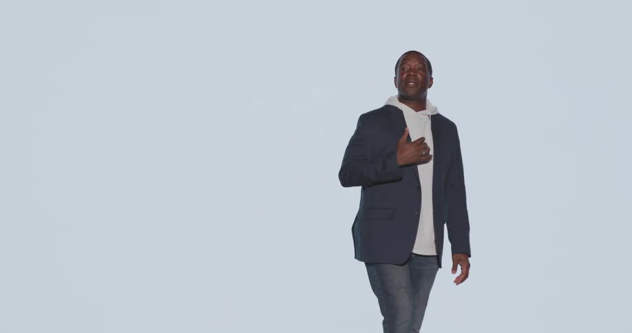 Man standing in blazer and an auditorium lecturing