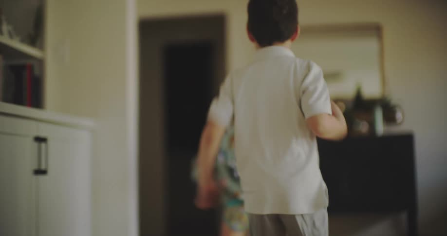 Two little boys running around the house
