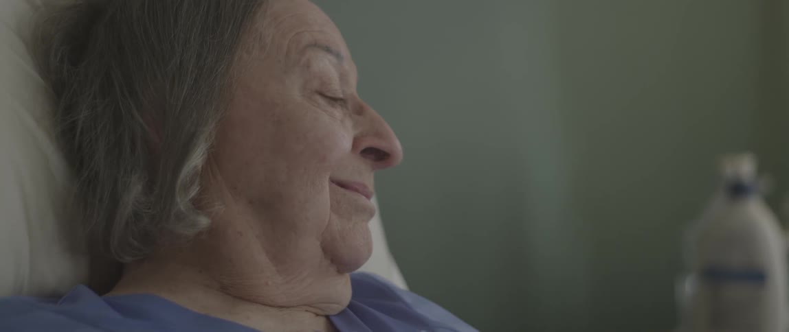 A woman is laying in bed smiling