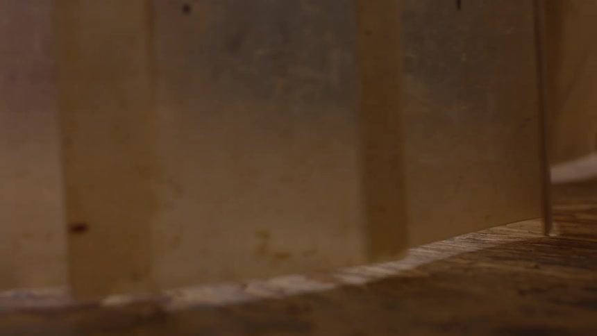 A closeup of the feet of a person walking through a curtain of hanging plastic strips likely in a restaurant