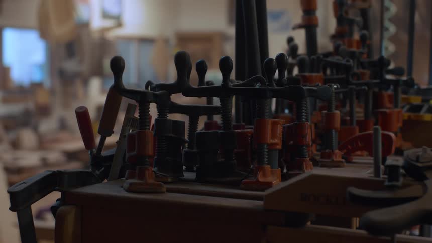 A row of clamps stands in an indoor workshop setting