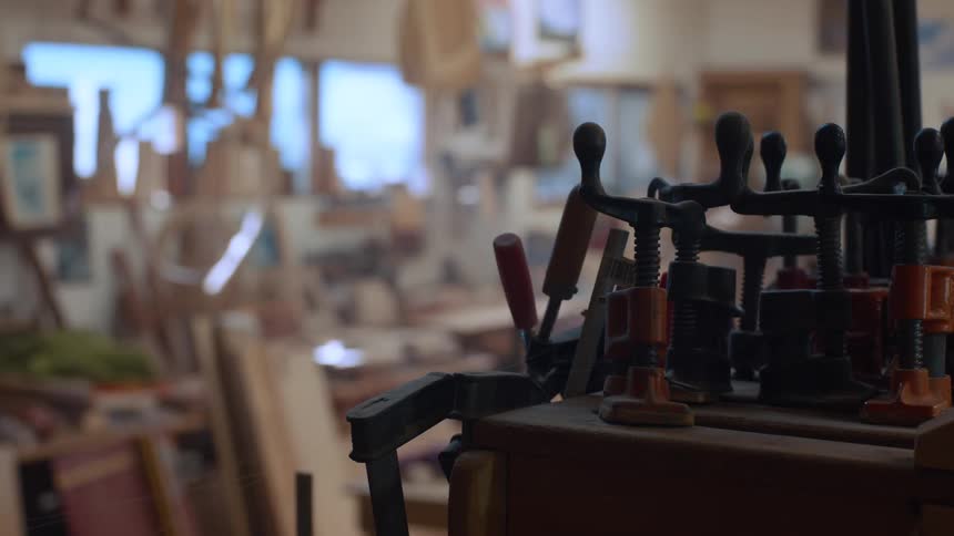 Some clamps tightening on a wooden object in a workshop