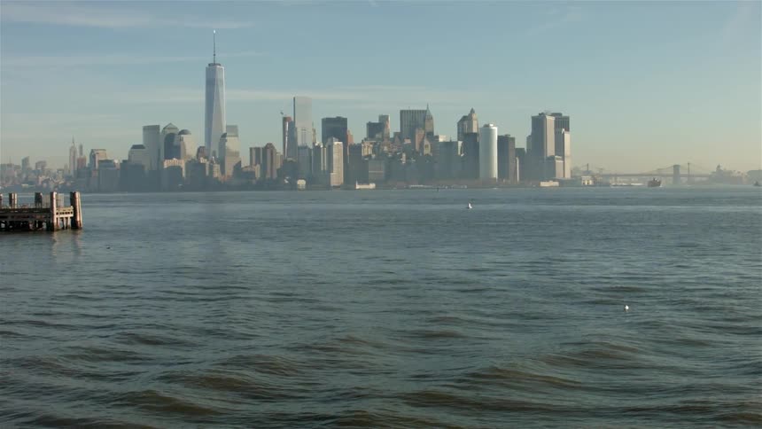Waves in an ocean harbor with a city skyline