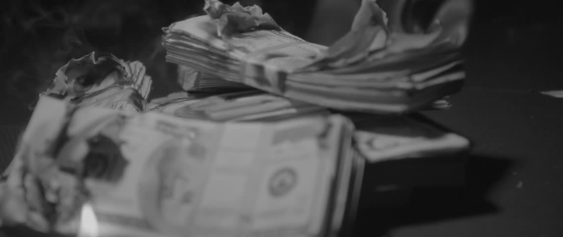 Money that has been set on fire is smoking and curling up