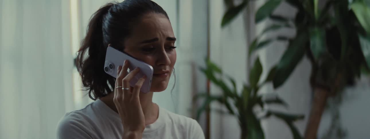 Dejected woman talking on a call via smartphone