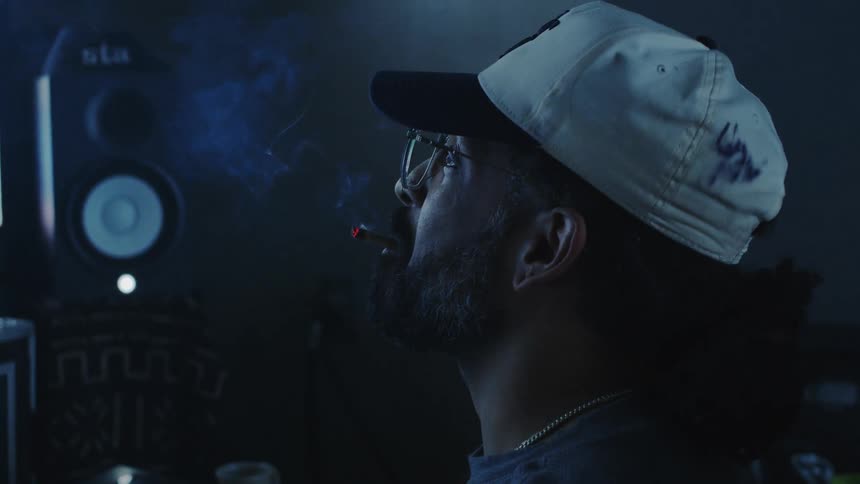 A man is smoking and using his computer