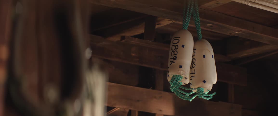 A clip of a buoys hanging from a wooden ceiling in a fisherman's shop
