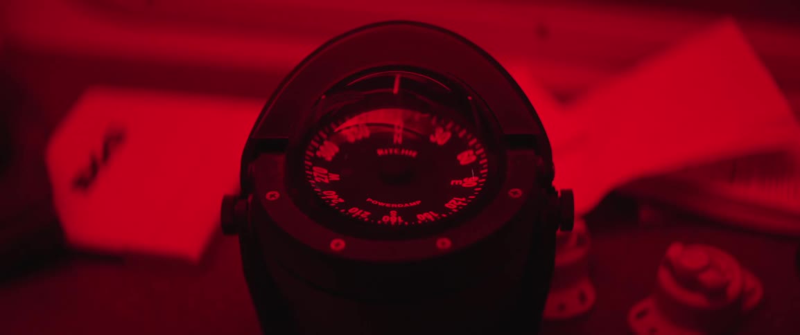 Close up of a boat's compass in a cabin under red lights