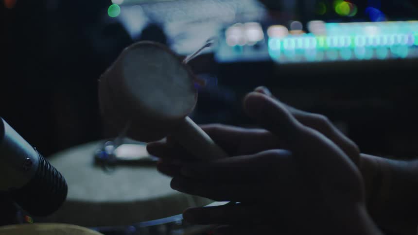 Pair of hands playing a small drum instrument