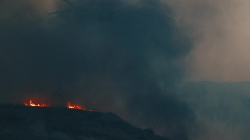 Helicopter flying over a burning area