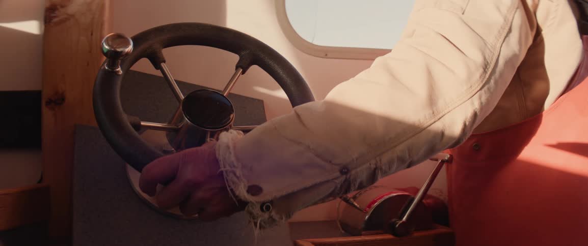 The arm of a captain at the helm of their fishing boat