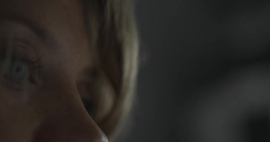 Woman staring forward in a dark room