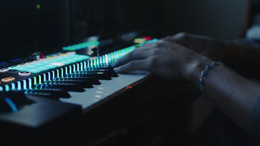 A man is playing the keyboard in the studio