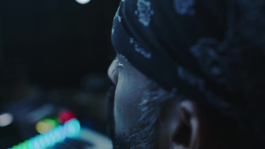 Side portrait of a man in a bandana looking forward concentrated