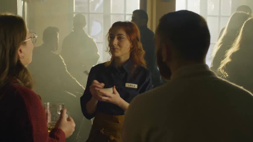 A server takes an order from customers in a dimly lit restaurant
