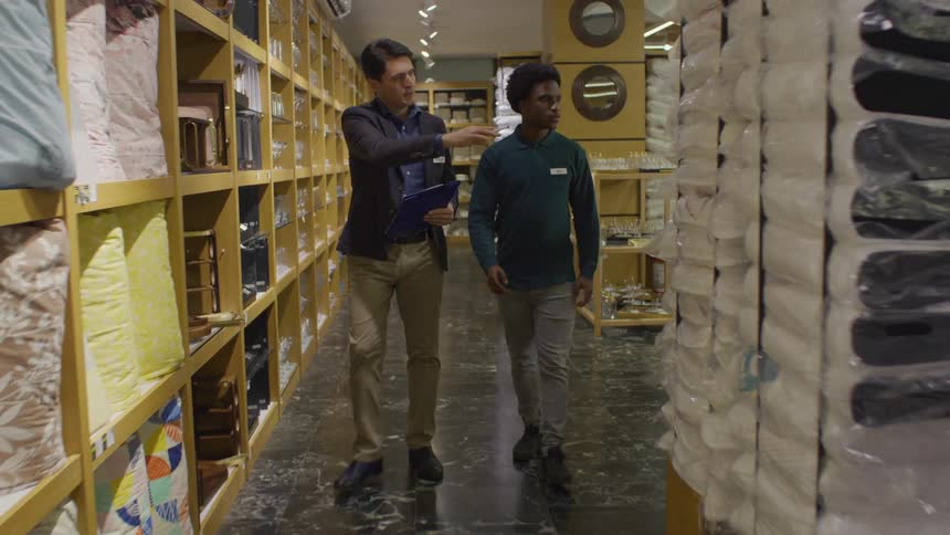 Two men walking down the aisle of a store